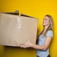 Smiling woman holding a large box, photo by bruce mars