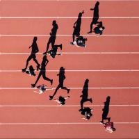 People running on a track with a leader in front