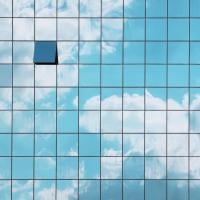 Building with clouds reflected on the side