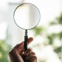 Person holding a magnifying glass