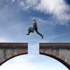 man jumping over hole in bridge