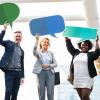 Coworkers holding up paper feedback speech bubbles