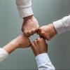 Four people fist-bumping in a workspace