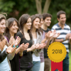 People applauding near a medal saying "2018"