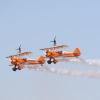 Two identical airplanes performing a stunt in tandem