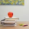 A stack of books and pens on a desk