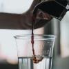 Espresso being poured into a cup of water and mixing